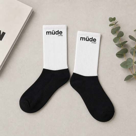 Schwarz-weiße Statement Socken müde von JoisPulse, flach liegend fotografiert