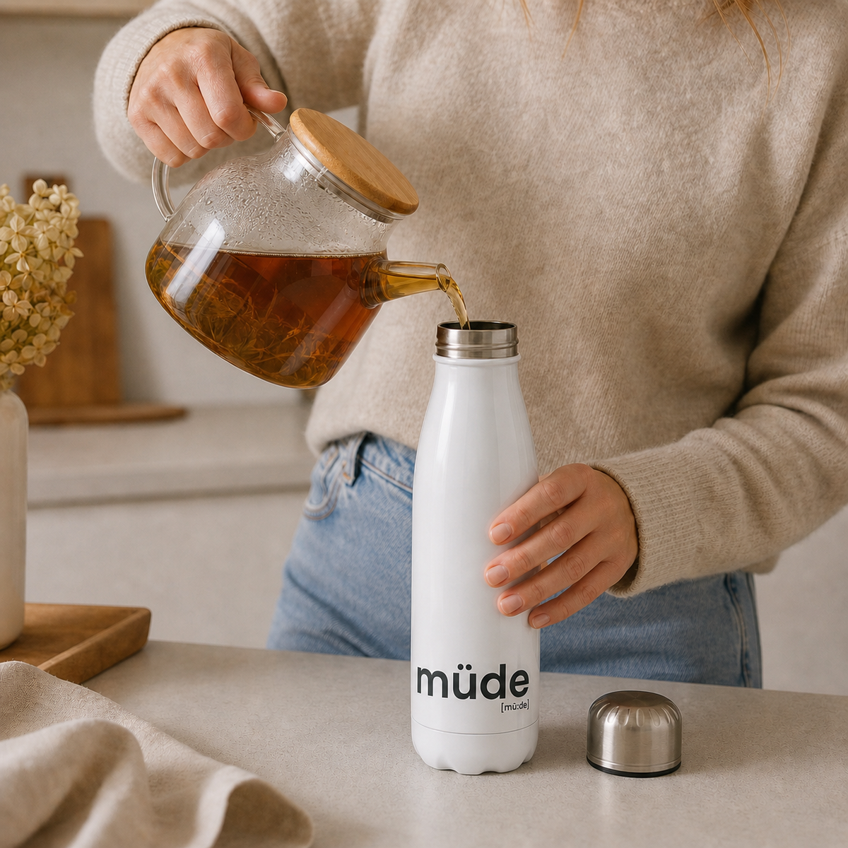 Frau gießt Tee in die JoisPulse Thermoflasche mit dem Statement müde