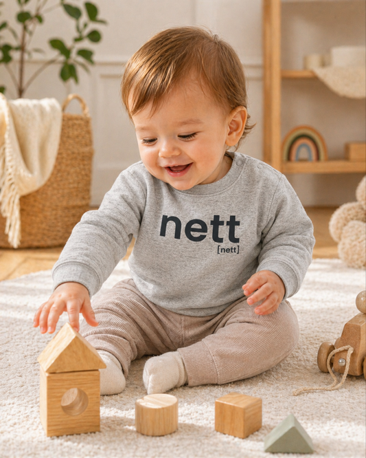 Baby mit Spielzeug im JoisPulse Baby Sweatshirt mit dem Statement nett