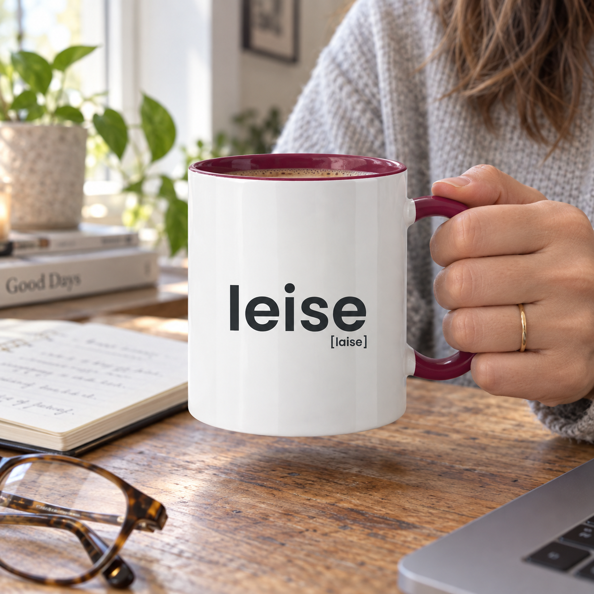 Leise Tasse mit bordeauxfarbenem Henkel am Schreibtisch
