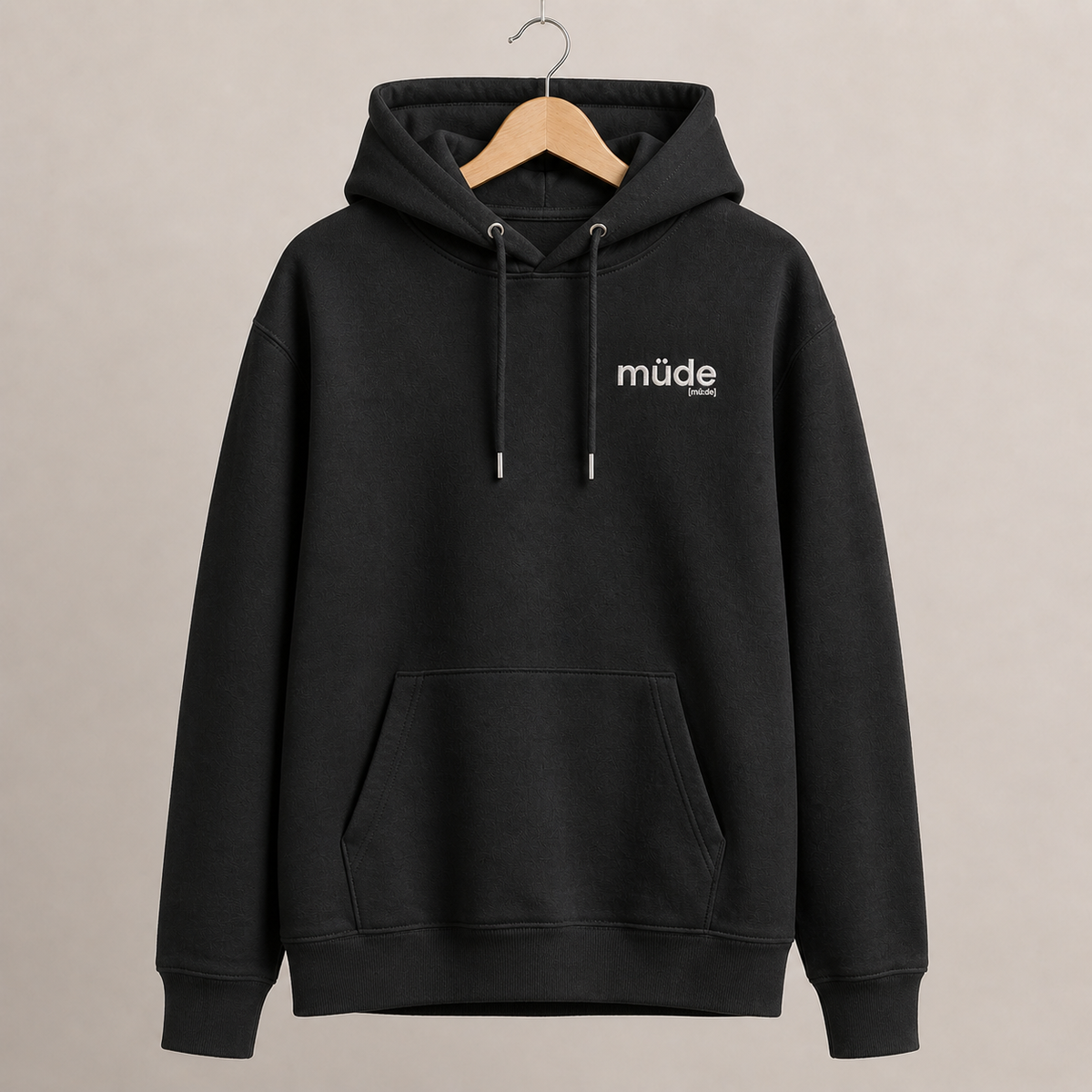 Schwarzer Bio Hoodie müde von JoisPulse mit gesticktem Statement, flach liegend