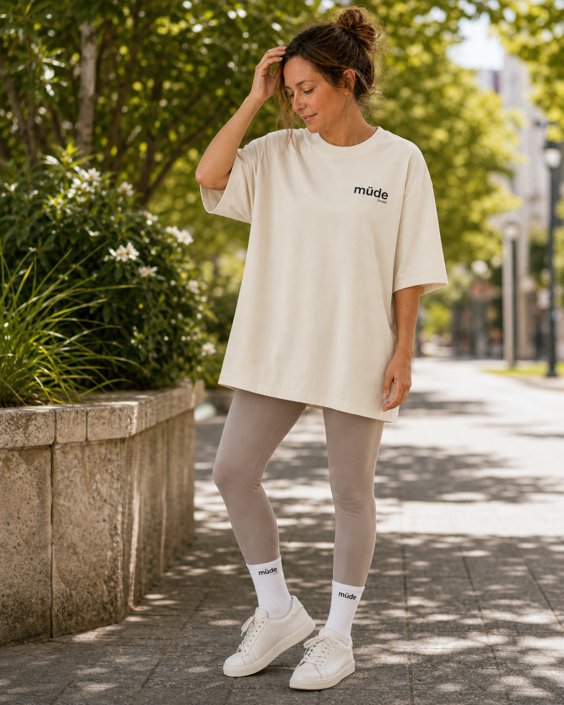 Frau draußen in Leggings trägt das JoisPulse Oversized T-Shirt mit dem Statement müde