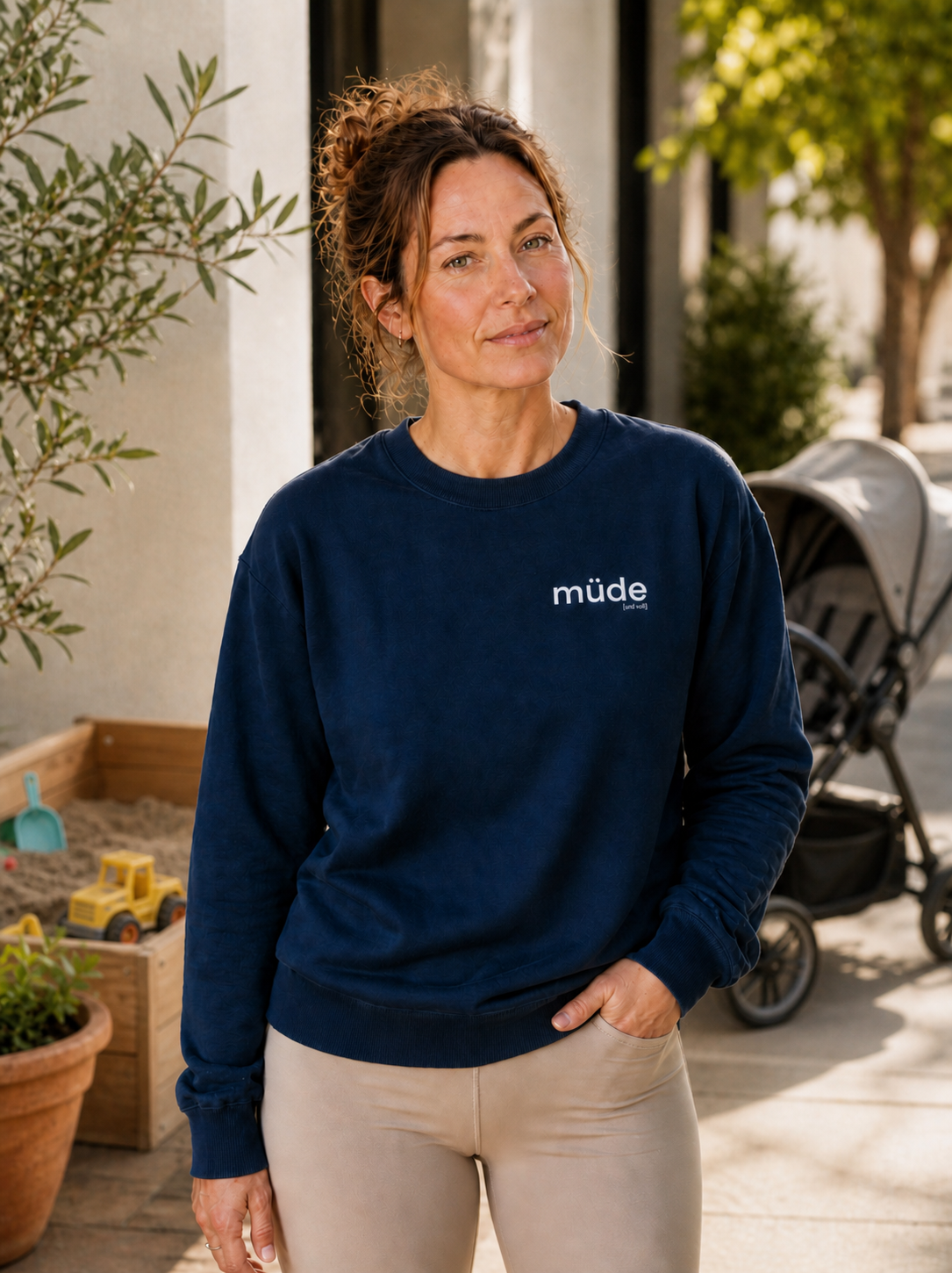 Frau mit Kinderwagen trägt das JoisPulse Oversized Sweatshirt mit dem Statement müde