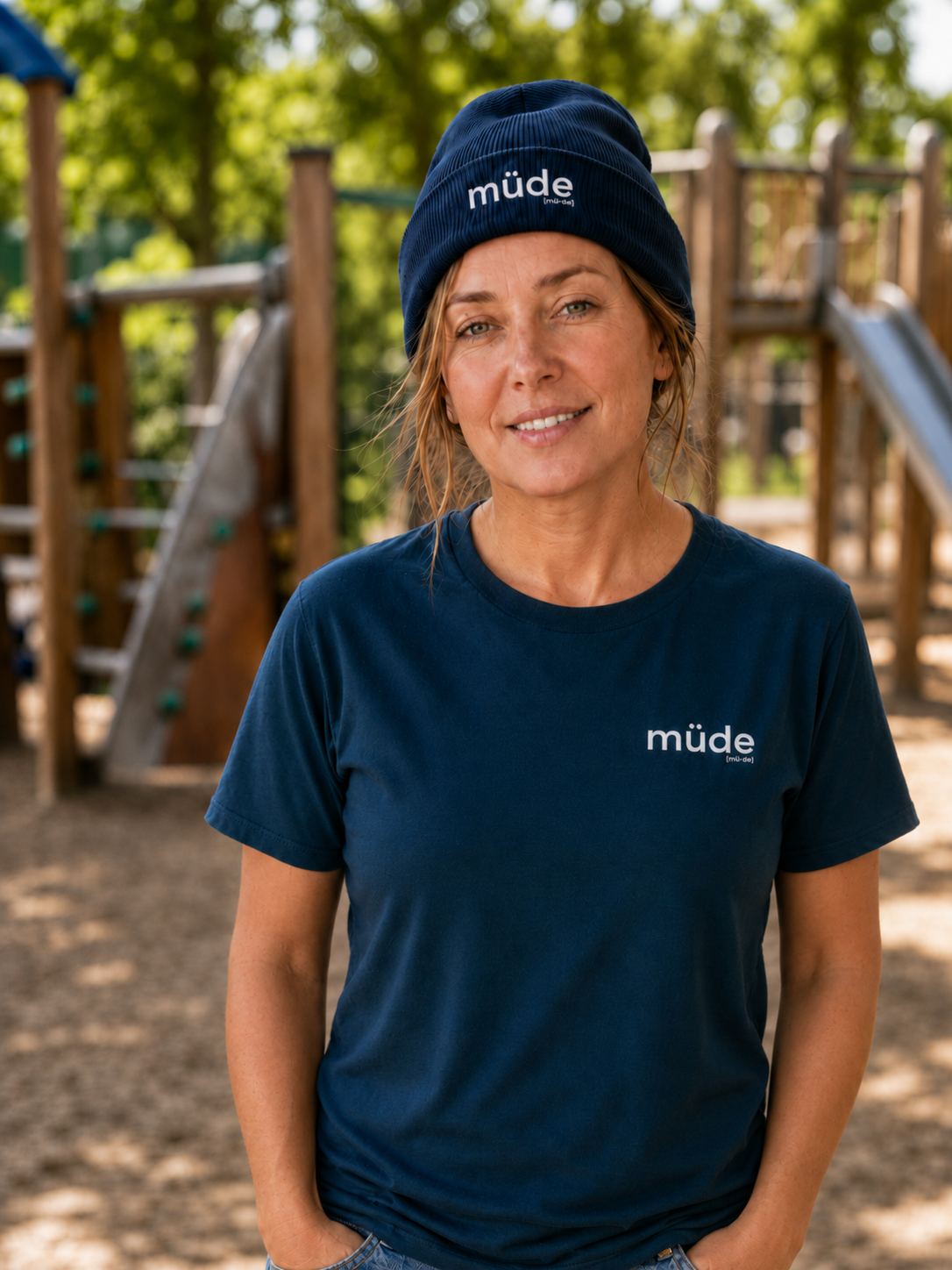 Frau auf einem Spielplatz trägt das JoisPulse T-Shirt mit dem Statement müde