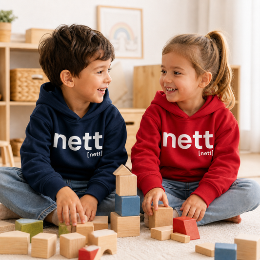 Zwei Kinder beim Spielen in JoisPulse Kinder Hoodies mit dem Statement nett